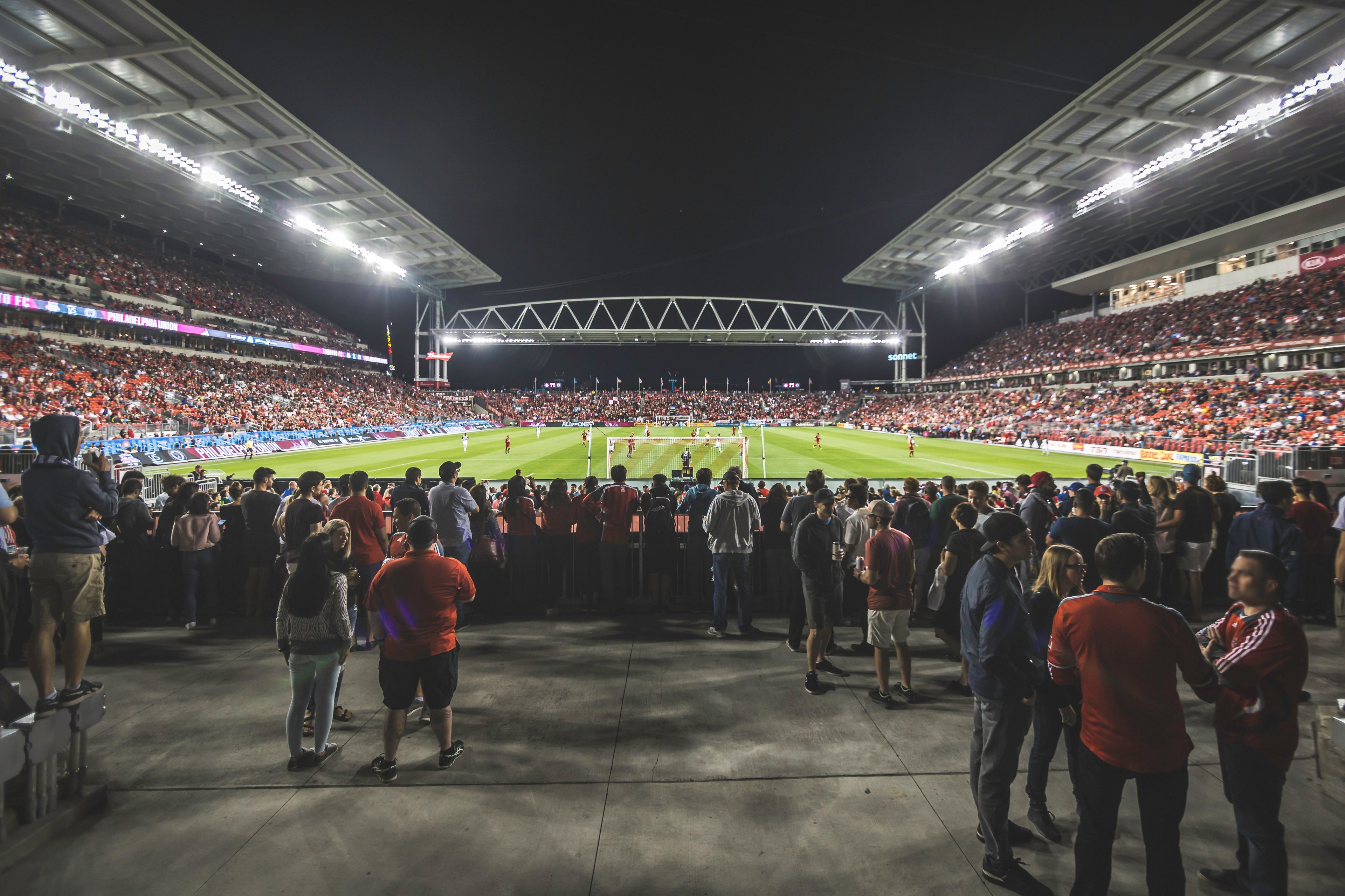 Soccer match in progress at night with fans in the stands